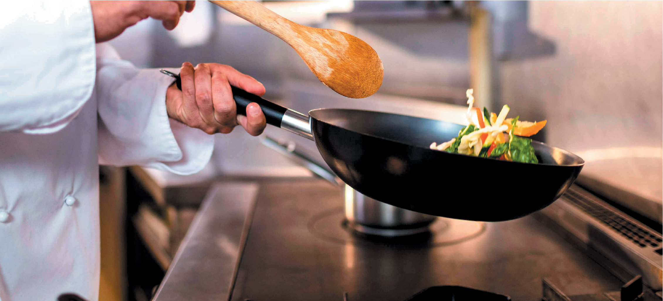 Chef performing a cooking demonstration sautéing vegetables