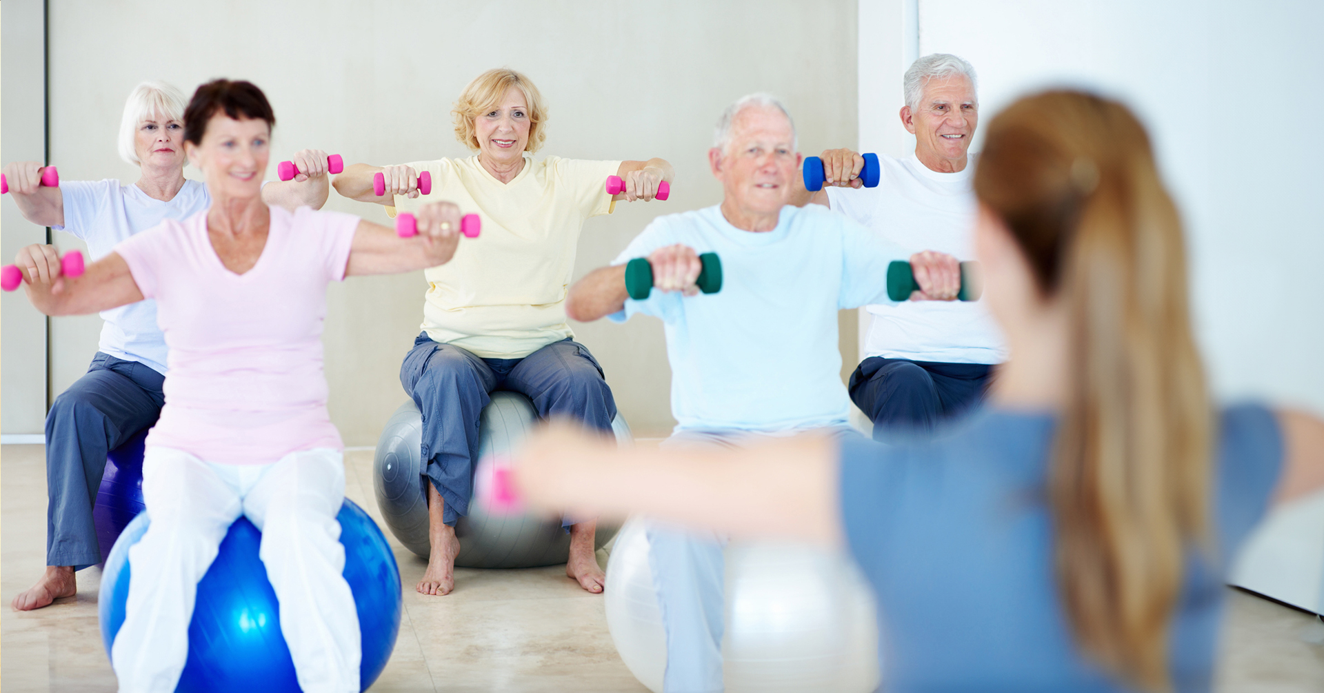 caregiver teaching aerobics to a group of seniors